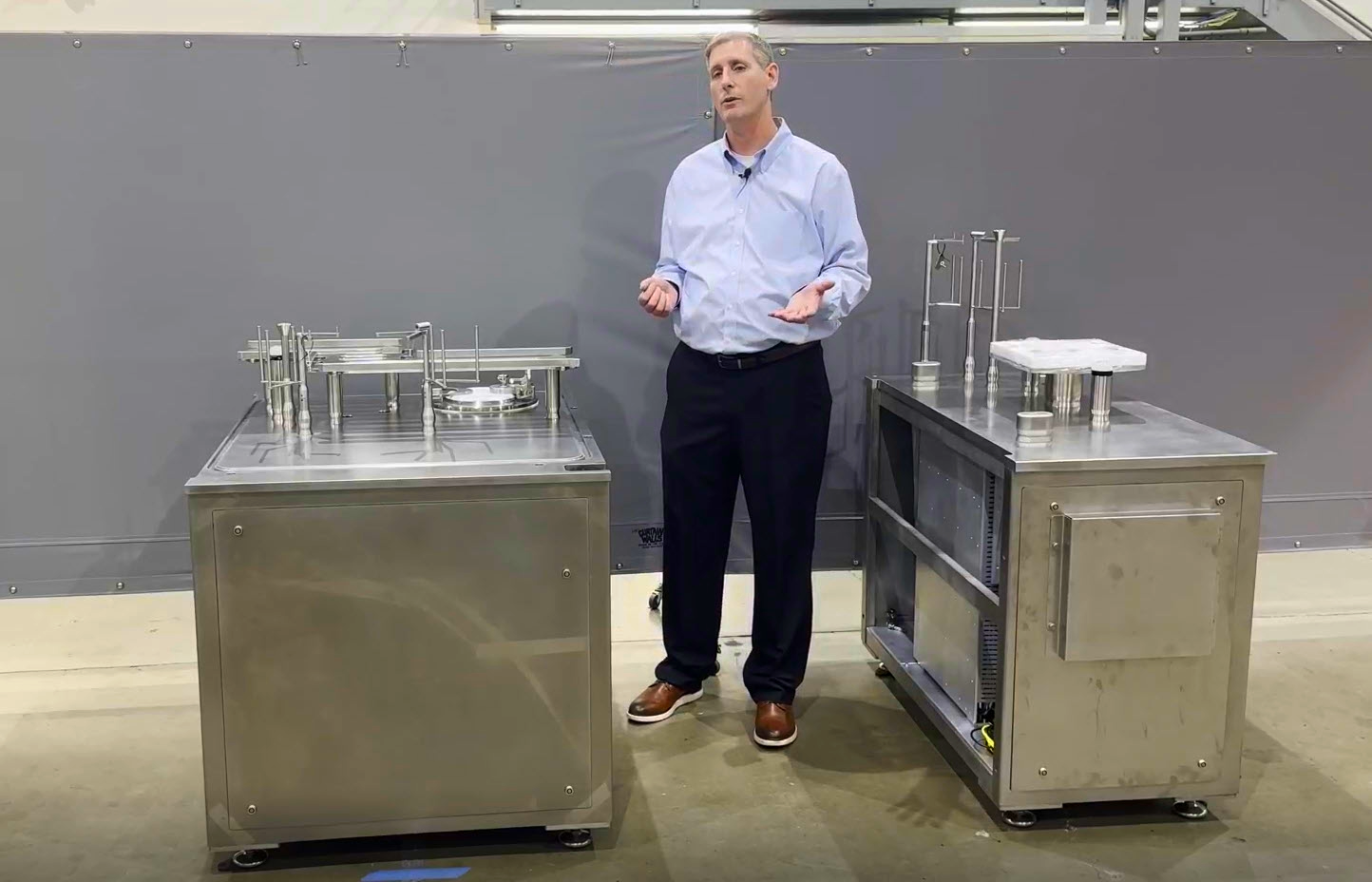 AST Josh Russell in front of modular aseptic fill finish products for pharmaceutical manufacturing