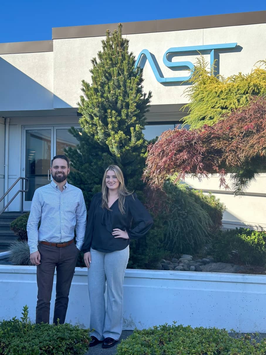 Photo of Kacie and Max in front of the AST headquarters in Tacoma Washington